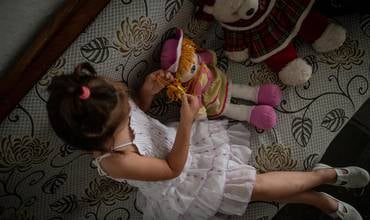 niña en su hogar jugando con una muñeca