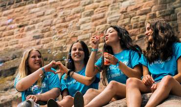 Grupo de chicas con camiseta de UNICEF jugando con pompas de jabón