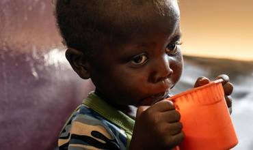 Un niño con desnutrición en República Centroafricana bebe leche fortificada.