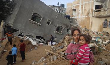 Abeer, de 12 años, sostiene en brazos a su hermana Zahra, de 4, frente a su casa destruida en Rafah, al sur de la Franja de Gaza.