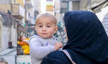 Abd Alwahab, de 3 años, y su madre Manal, en el exterior de un centro de salud y nutrición apoyado por UNICEF en Nayrab, ciudad de Alepo, Siria, el 12 de febrero de 2024.