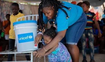 Lavado de mans en Haití para reducir a transmisión do cólera.