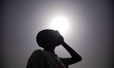 Un niño de Sudán se tapa los ojos para protegerse del sol