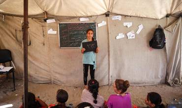 El 15 de agosto de 2024, en el Campamento Deir Al-Balah en la Franja de Gaza, Estado de Palestina, Hala, de 11 años, sostiene una pizarra que muestra el número de días escolares que ha perdido: 313