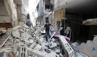 Niños y sus familias huyen de sus hogares, caminando entre los escombros de carreteras y edificios destruidos en el campo de refugiados de Yenín, en el norte de Cisjordania, debido a la continua escalada de violencia.