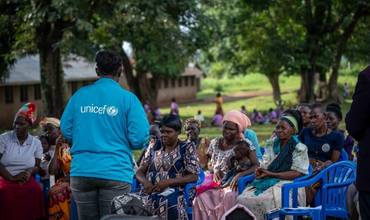 Pais que asisten a unha sesión estruturada de crianza na escola primaria Kanigiro no subcondado de Bugambe no distrito de Kikuube.