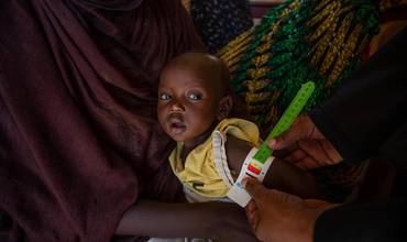Personal sanitario mide la circunferencia del brazo de un niño para comprobar si sufre desnutrición