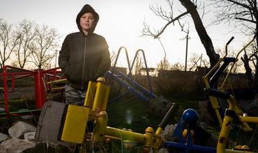 Timofii, de 11 años, posa delante de las ruinas del jardín de infancia al que asistía en el pueblo de Partyzanske, en la región de Mykolaiv, destruido por los bombardeos