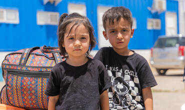 niños y niña desplazados con sus pertenencias