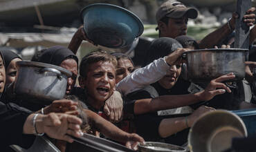 niño intentando conseguir algo de comida en Gaza