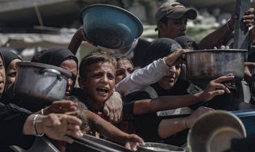 niño intentando conseguir algo de comida en Gaza