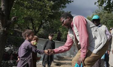 El Dr. Tajudeen Oyewale, representante de UNICEF en Afganistán, da la mano a un niño superviviente de la tragedia