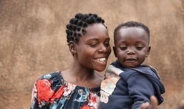 madre sonríe junto a su bebé en Zambia