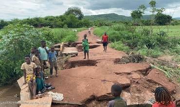 Niños y niñas entre socavones. El 17 de enero de 2026, las carreteras se inundan tras las lluvias torrenciales caídas en Buzi, provincia de Sofala, Mozambique.
