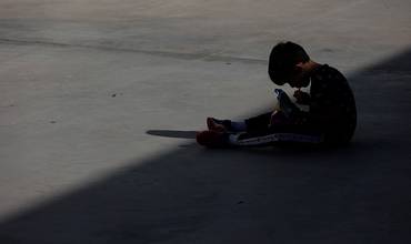 Un niño almuerza en el patio de su colegio a la sombra durante el recreo