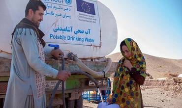 Niña recoge agua suministrado por un camión cisterna de UNICEF