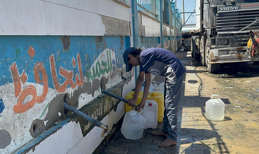 niño cogiendo agua en Gaza