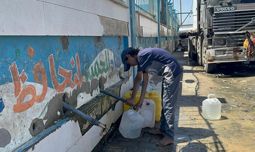 niño cogiendo agua en Gaza