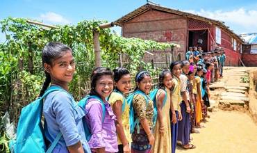 Alumnas rohingya portando mochilas proporcionadas por UNICEF en un campamento de refugiados de Bangladesh