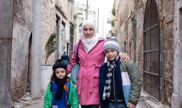 Una madre con sus niños a la salida de un centro de protección infantil de UNICEF en Siria.