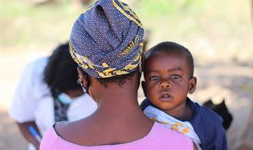 Una madre sostiene en brazos a su hijo en Mozambique