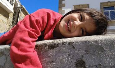 Una niña sonríe y juega en las calles de una localidad Gallega