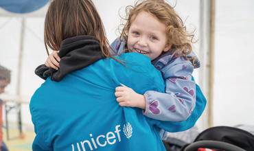 El 7 de abril de 2022, Emma, de 5 años, juega con un miembro del personal de UNICEF en un Punto Azul en el paso fronterizo de Isaccea (Rumanía). Emma, su madre Yulia y su hermano pequeño llegaron al centro después de viajar desde Odessa (Ucrania).