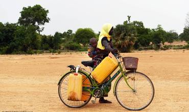 Una mujer con su hijo camino a un pozo, en Fada, en el este de Burkina Faso.
