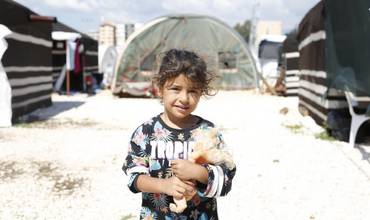Una niña con su muñeco en uno de los refugios temporales en Turquía después de los terremotos.