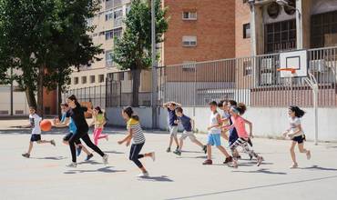 Niños y niñas jugando al baloncesto.