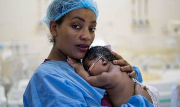 Omnia junto a su madre, en una Unidad de Cuidados Intensivos, en Sudán.