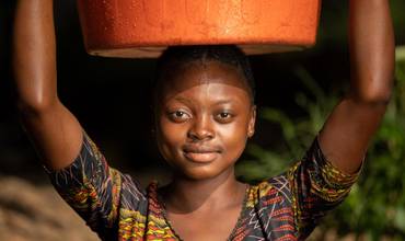 Una niña recoge agua en una fuente establecida por UNICEF. 