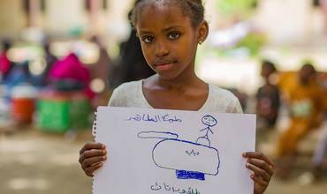 Una niña dibuja sus vivencias en Sudán.