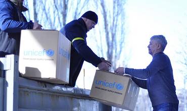 Imagen de dos trabajadores de UNICEF descargando cajas con suministros