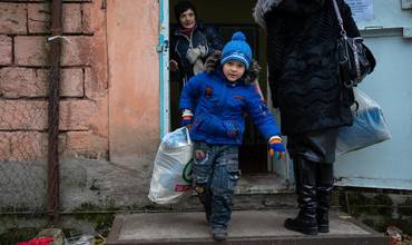 Un niño Ucraniano recoge un kit de prendas de invierno facilitado por UNICEF