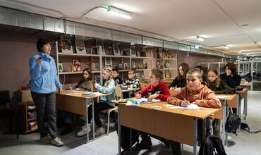 En el refugio antiaéreo que hay bajo una escuela a las afueras de Kharkiv (Ucrania), la profesora de matemáticas Tetiana se pasea por los pupitres de los niños.