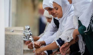 Una niña se lava las manos y la cara en las instalaciones de una escuela de Yemen