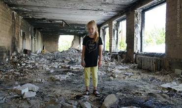 Una niña ucraniana entre los escombros de lo que fue su escuela