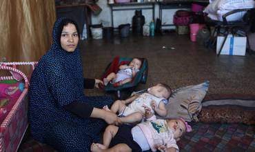 Eman, madre de 29 años con sus cuatro hijos, en una clínica pediátrica apoyada por UNICEF en Deir al-Balah, Franja de Gaza.