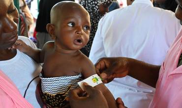 Personal sanitario mide la circunferencia del brazo de un bebé en Burkina Faso