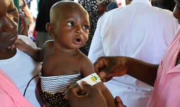 Personal sanitario mide la circunferencia del brazo de un bebé en Burkina Faso