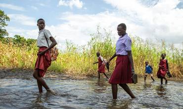 Estudiantes recorriendo caminos inundados en Sudán del Sur