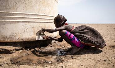 En el distrito de Libemuket, en el sur de Etiopía, afectado por el cambio climático, una niña bebe agua del grifo de un depósito proporcionado por UNICEF en respuesta a la sequía.