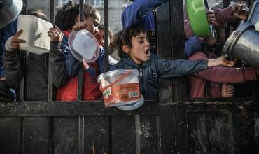 Niños y familias se agolpan para conseguir una ración de comida en Gaza