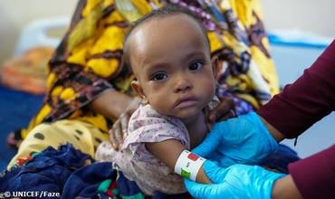 Personal sanitario mide la circunferencia del brazo de una niña