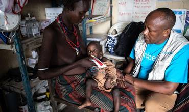 Un especialista en Nutrición de UNICEF entrega alimentos terapéuticos listos para usar (RTUF, por sus siglas en inglés) a una niña desnutrida en Etiopía