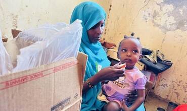 Una niña tomando alimento terapéutico contra la desnutrición en Sudán