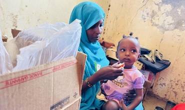Una niña tomando alimento terapéutico contra la desnutrición en Sudán