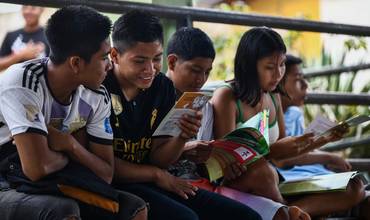 Un grupo de adolescentes leen folletos informativos sobre la prevención del sida