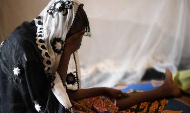 Una niña africana se tapa el rostro